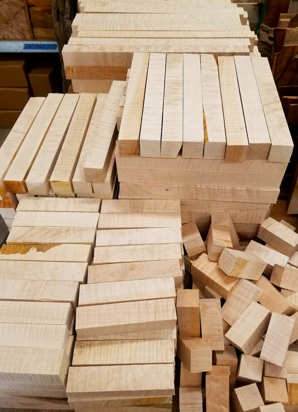 Figured maple wood spindles stacked in a large row